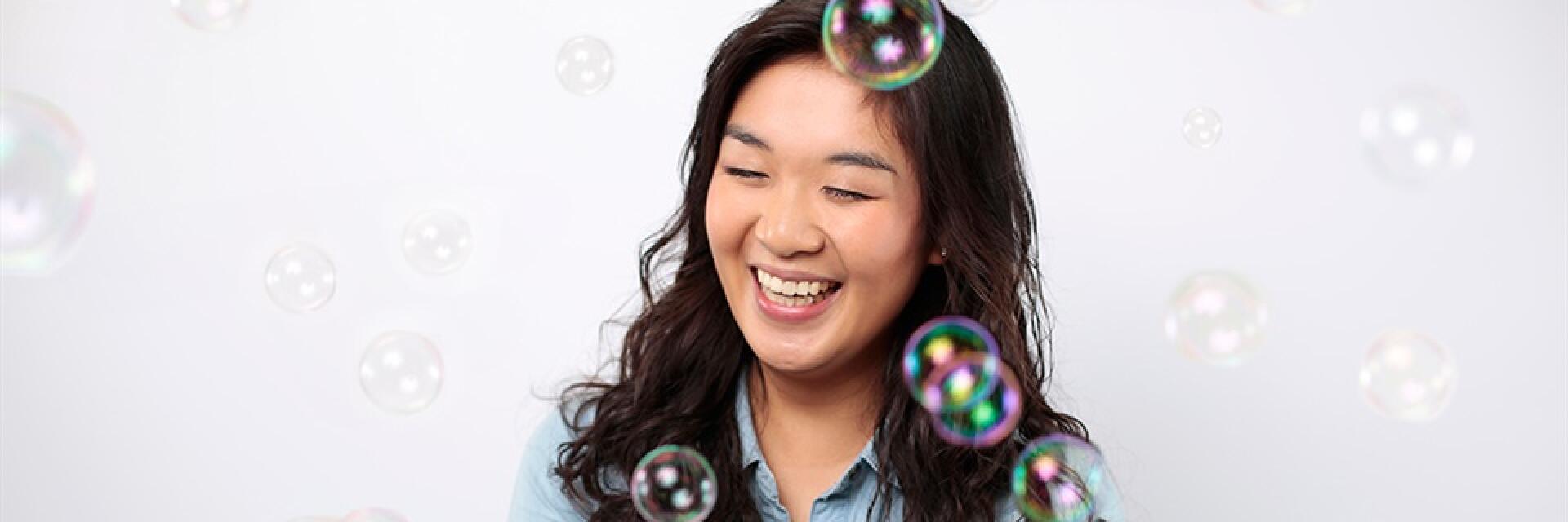 Woman with bubbles floating around her in the air